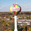 Colorful water tower with "OAKLANDON COMMUNITY" surrounded by autumn trees, evoking community, nostalgia, and a cozy atmosphere.