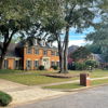 Suburban street with classic brick homes, lush lawns, and trees, evoking calm, tradition, and a peaceful lifestyle.