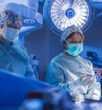 Surgical team in scrubs and masks focused on a procedure, embodying teamwork, intensity, and commitment to patient care.