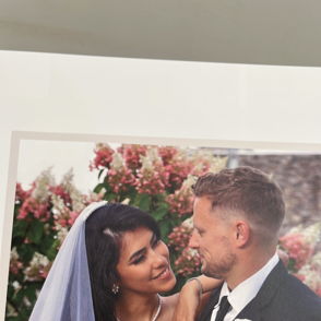 A joyful couple at their wedding share a loving gaze, surrounded by vibrant flowers, capturing love and celebration.