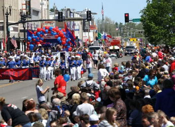 A lively parade with a large crowd, colorful decor, and enthusiastic participants, evoking joy and community spirit.