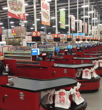 Spacious grocery store checkout area with bright red counters, touchscreens, organized bags, evoking efficiency and calmness.