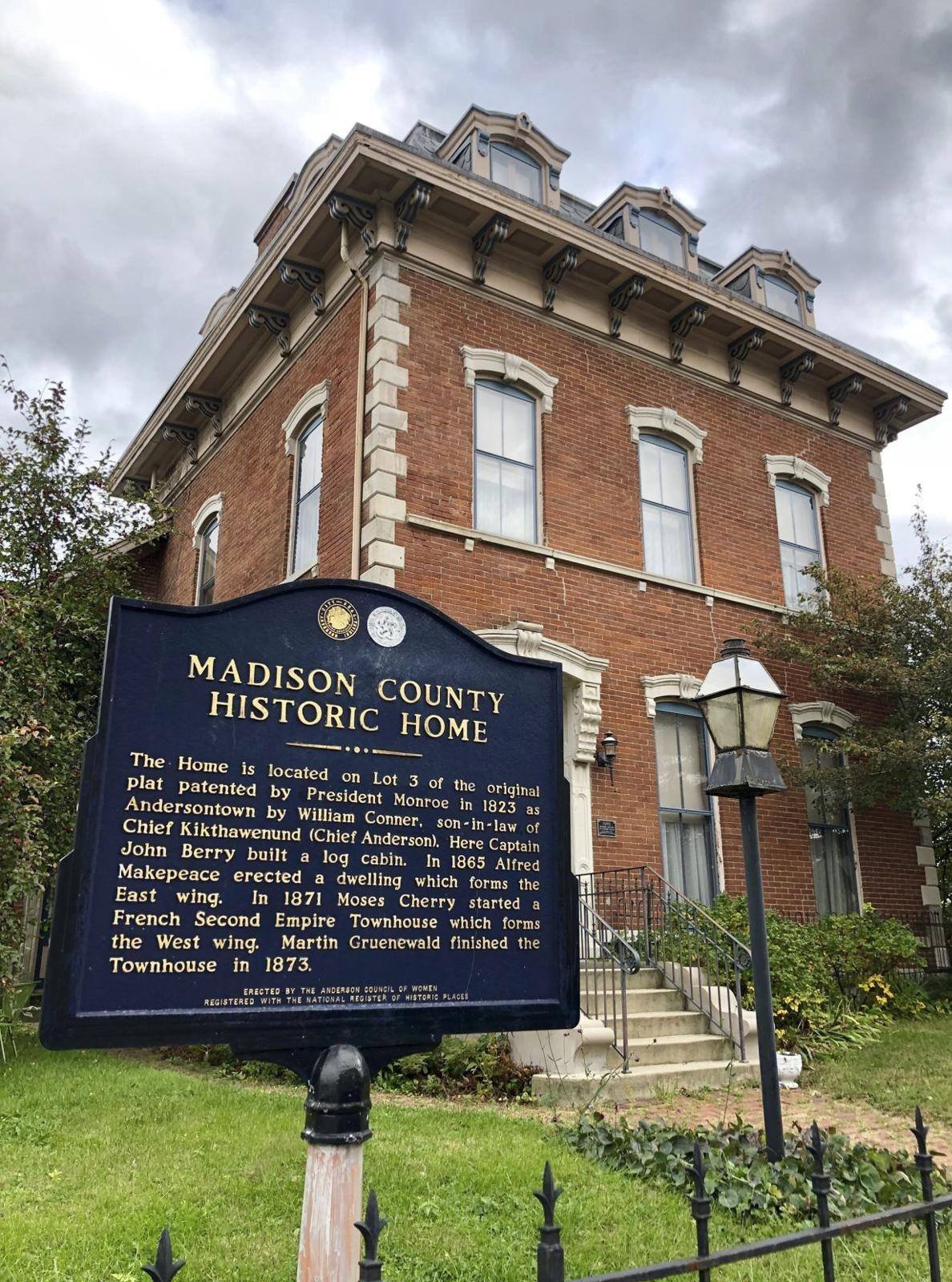 Historic brick home from the late 19th or early 20th century, featuring grand architecture and a historical marker.