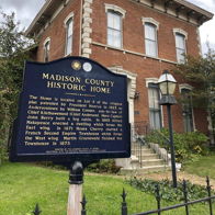 Historic brick home from the late 19th or early 20th century, featuring grand architecture and a historical marker.