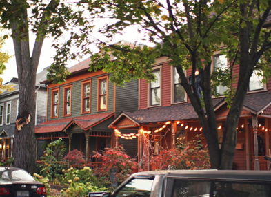 Colorful houses with soft lighting create a cozy, inviting street, surrounded by greenery, evoking nostalgia and community.