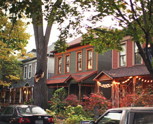 Colorful houses with soft lighting create a cozy, inviting street, surrounded by greenery, evoking nostalgia and community.