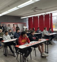 A modern classroom with diverse students attentively engaged in learning, featuring bright decor and a collaborative atmosphere.