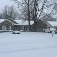 Cozy brick house in snowy scene with trees; evokes tranquility, warmth, and solitude amidst the winter landscape.