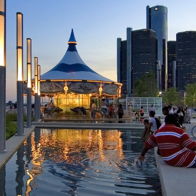 A lively urban scene with a sunset, carousel, and skyscrapers, showcasing joy and community by the water.