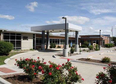 Modern building in a landscaped setting with vibrant roses, exuding warmth, serenity, and a sense of community.