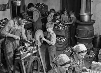 Black-and-white photo of workers, including children, laboring in a dim room, evoking nostalgia and community resilience.