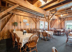 Cozy restaurant with rustic wooden decor, warm lighting, inviting atmosphere, and tables ready for dining or quiet reflection.