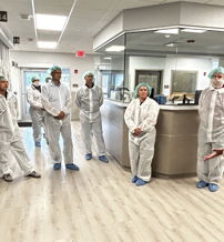 Group of healthcare professionals in scrubs discuss in a modern hospital, highlighting teamwork and commitment to care.