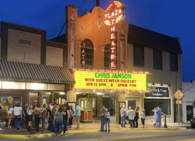 A lively theater scene at night with a bright marquee for Chris Janson, featuring a joyful crowd in a charming setting.