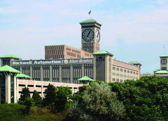 Large industrial building with clock tower, blending modern and classic architecture amid greenery, indicating stability and professionalism.