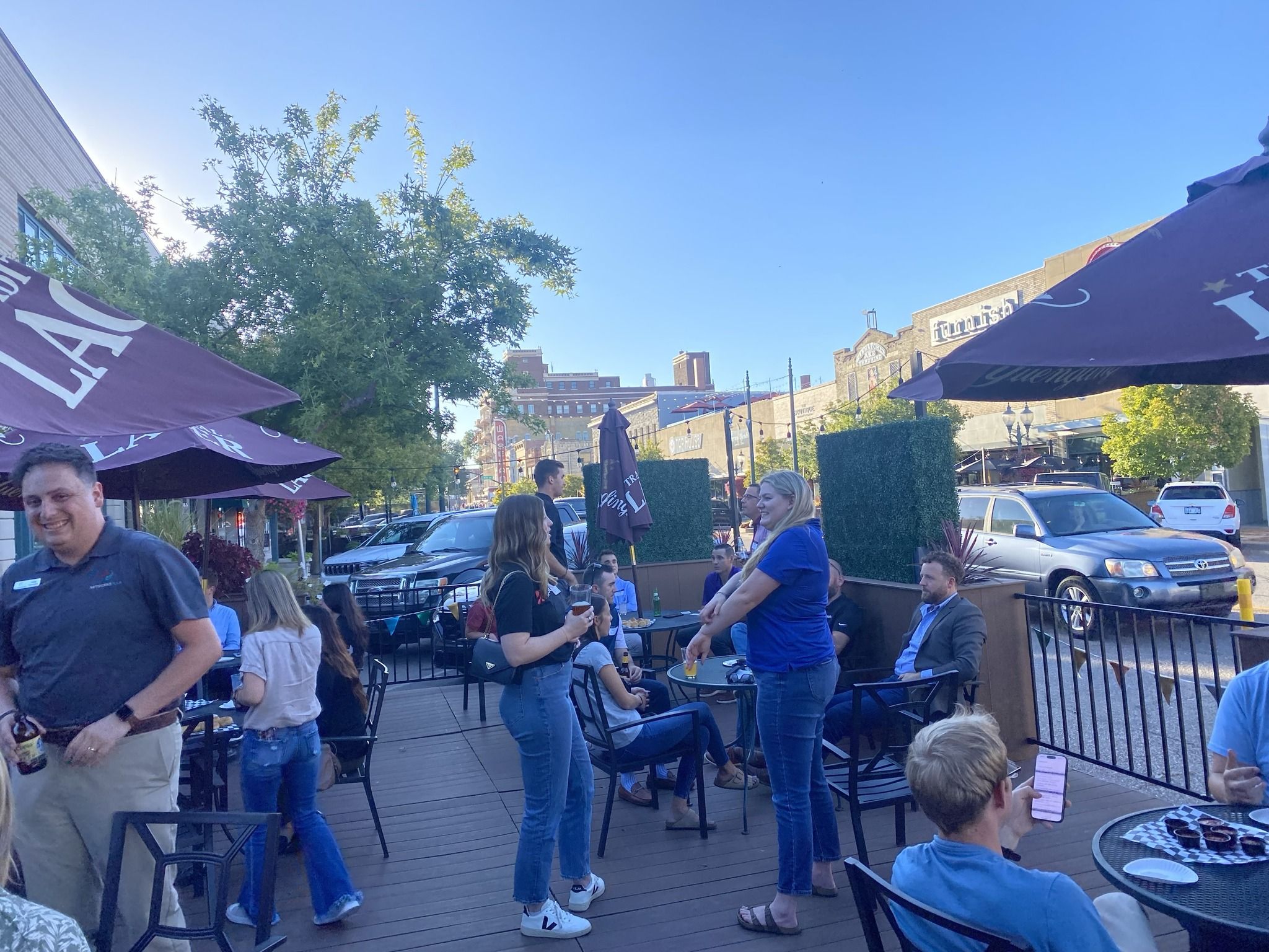 Lively outdoor cafe scene with diverse people enjoying conversation under sunny skies, evoking joy, relaxation, and community.