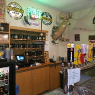 Cozy tavern interior with wooden shelves, beer taps, neon signs, and rustic decor, creating a warm, inviting atmosphere.