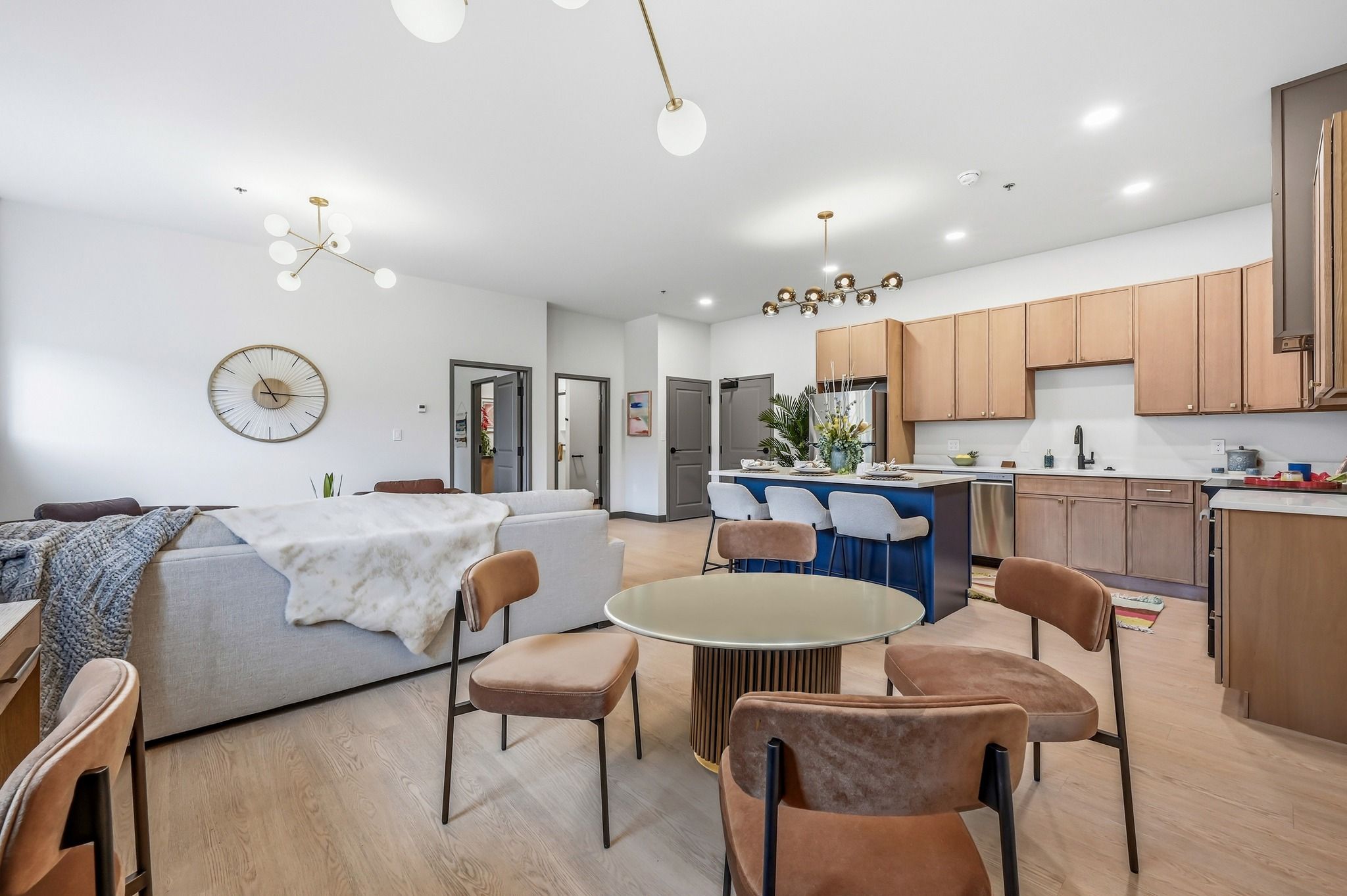 Modern open-concept living space with cozy sofa, round coffee table, and stylish kitchen, evoking warmth and relaxation.