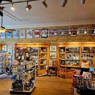 Colorful display shelf in a gift shop, featuring framed pictures, mugs, and decor, evoking nostalgia and curiosity.