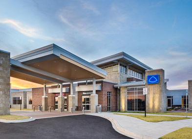Modern building with stone and glass design, warm sunset colors create a welcoming, calm atmosphere and sense of community.
