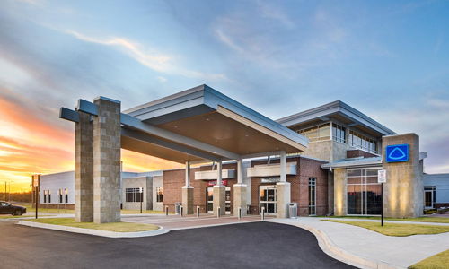 Modern building with stone and glass design, warm sunset colors create a welcoming, calm atmosphere and sense of community.