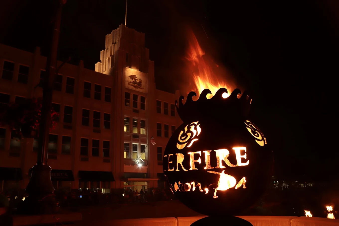 A vibrant torch displays "FIRE," glowing warmly against a nighttime backdrop, evoking passion and festive energy.