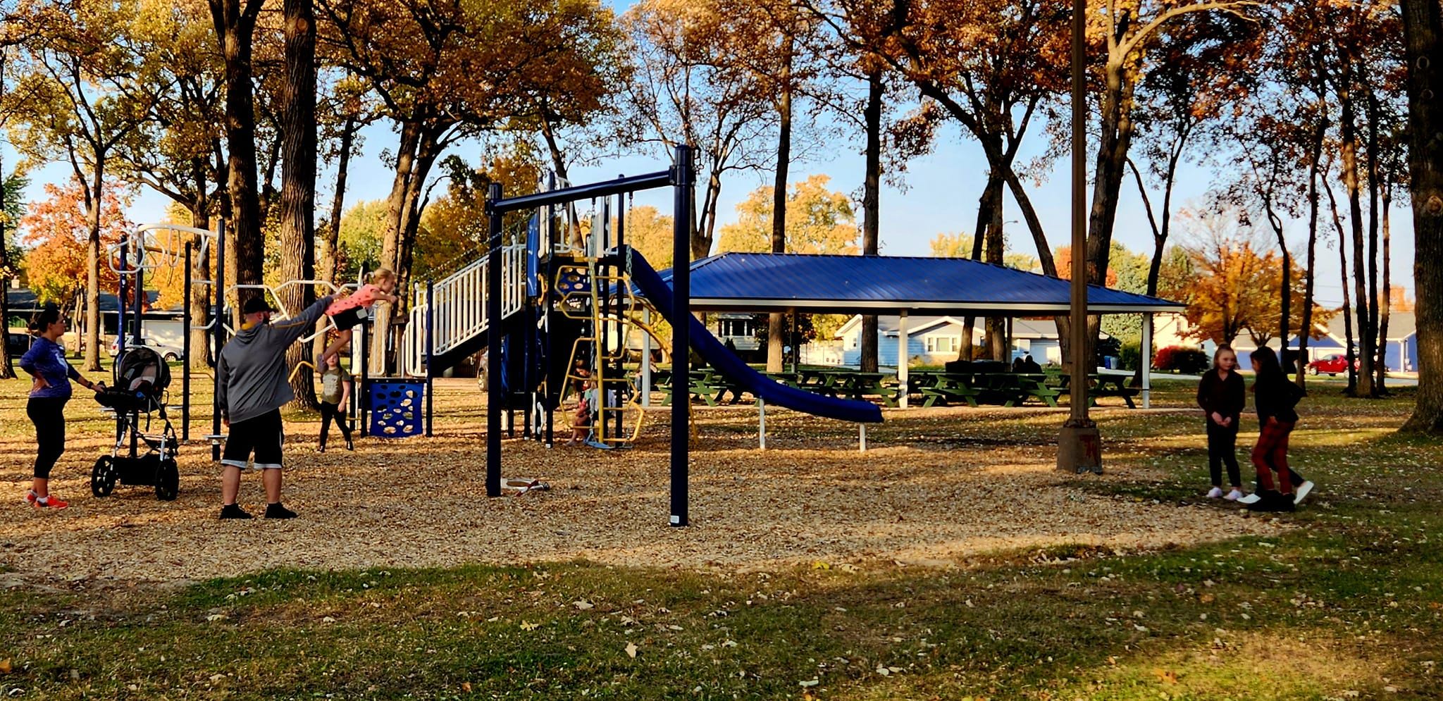 Lively park scene with people exercising among autumn trees, fostering community and energy in a vibrant setting.