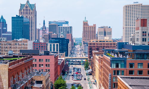 Vibrant urban landscape with brownstones, modern skyscrapers, and lively street, evoking energy and a sense of community.