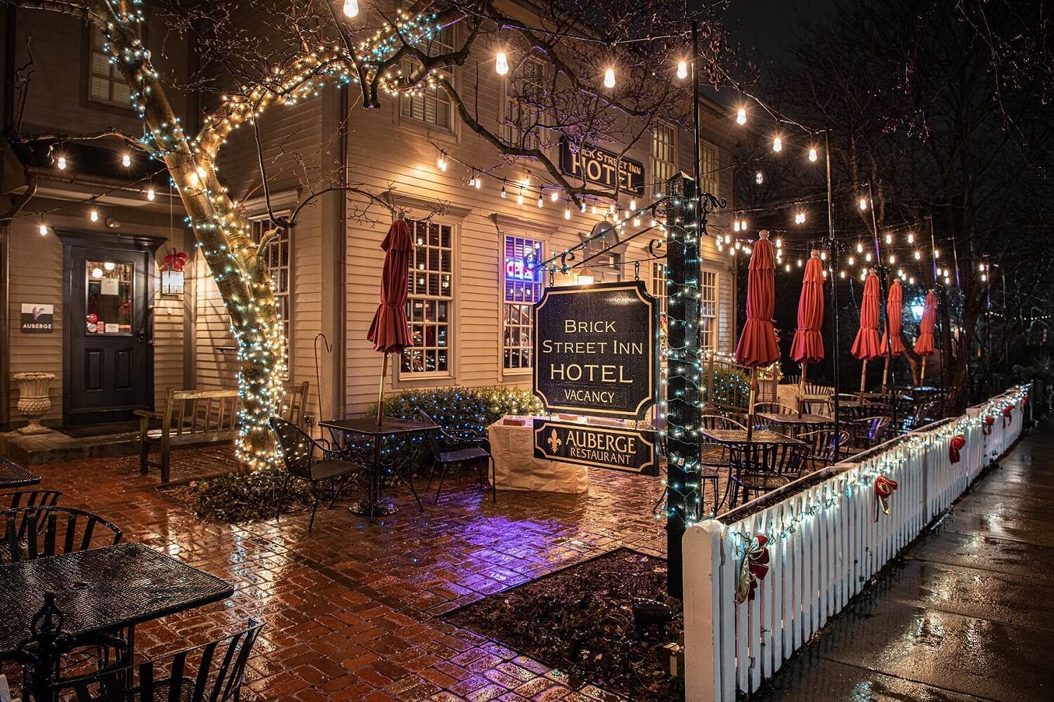 Cozy inn at night with warm string lights, rustic charm, outdoor seating, and a tranquil atmosphere. Perfect for relaxation.