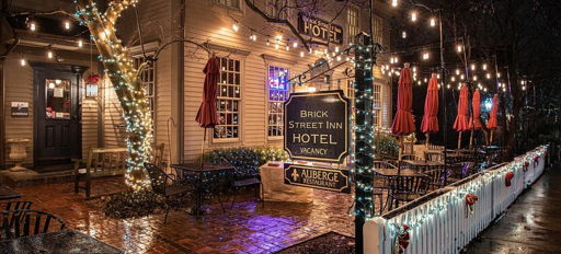 Cozy inn at night with warm string lights, rustic charm, outdoor seating, and a tranquil atmosphere. Perfect for relaxation.