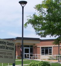 Greeley County Health Services building, modern design, accessible paths, greenery exuding care, community, and support for health needs.