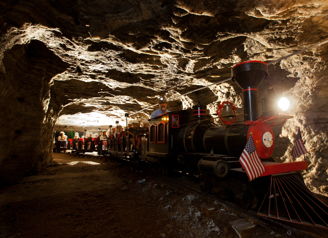 A colorful train in a cave tunnel evokes adventure and nostalgia, inviting exploration and wonder.