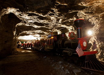 A colorful train in a cave tunnel evokes adventure and nostalgia, inviting exploration and wonder.