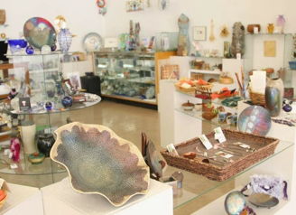 Art store filled with colorful glass, pottery, and decor, inviting creativity and inspiring curiosity about handcrafted goods.