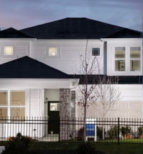 A modern two-story house with white siding, stone accents, and a tranquil twilight setting evokes comfort and hope.