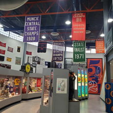 Indoor space celebrates sports achievements with colorful banners, display cases, and a nostalgic atmosphere, inspiring community pride.