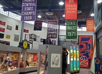 Indoor space celebrates sports achievements with colorful banners, display cases, and a nostalgic atmosphere, inspiring community pride.