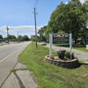 Welcoming sign for "Edgewood" along a peaceful road, surrounded by vibrant flowers and a friendly neighborhood atmosphere.