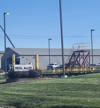Industrial facility with utility structures, American flag, and well-maintained grass, evoking stability and a sense of community.
