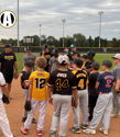 Youth baseball team in huddle, focused on coach, on a diamond field, exuding teamwork and anticipation for their game.