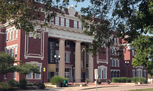 Brick building with tall columns, likely a museum or library, surrounded by greenery, bright lighting, and an inviting atmosphere.