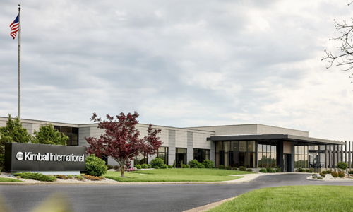 Modern corporate building with landscaping, American flag, evokes stability, professionalism, calmness, and productivity.