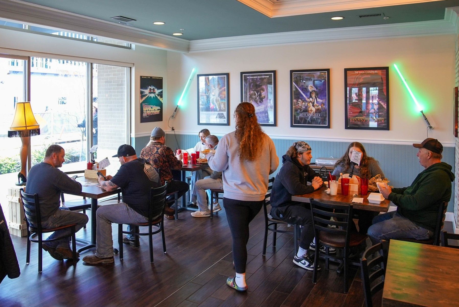 Cozy restaurant scene with lively patrons enjoying meals, warm lighting, and a welcoming atmosphere of camaraderie and comfort.
