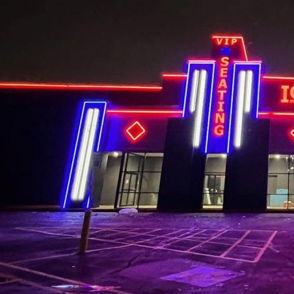 Modern ICON CINEMA exterior with vibrant neon lights, geometric design, evoking excitement for a fun movie night out.