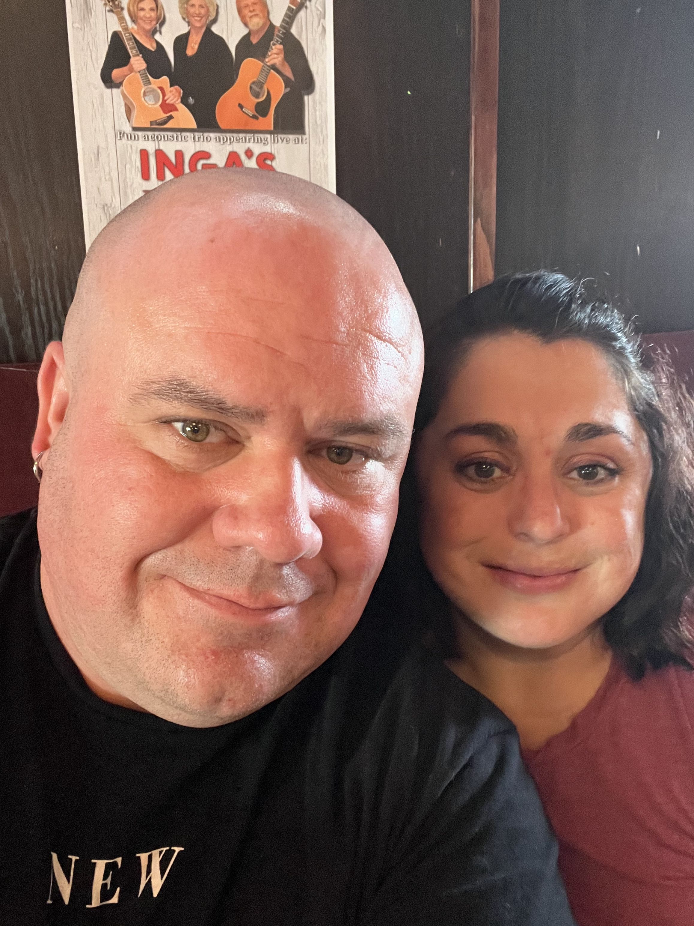 Two smiling individuals share a joyful moment in a relaxed, creative setting with musical instruments in the background.