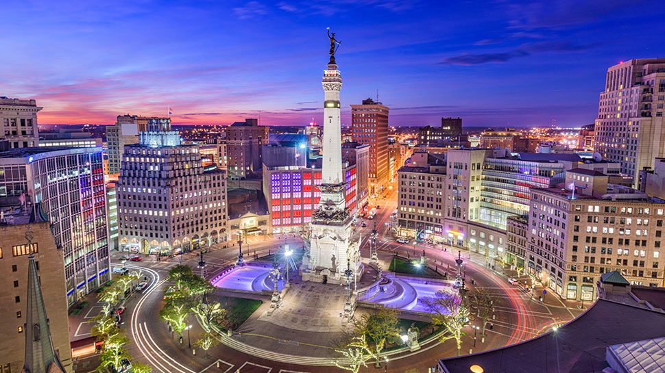 Twilight cityscape with a landmark monument, illuminated buildings, and a colorful sky, capturing urban vibrancy and tranquility.