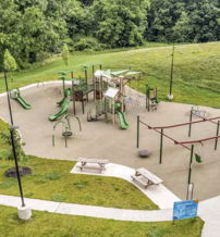 Playground with slides, swings, and climbing equipment amidst lush greenery, evoking joy and nostalgia for childhood adventures.