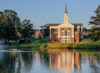 A peaceful landscape with a church by a calm lake, surrounded by greenery and soft sunlight, evoking serenity and spirituality.