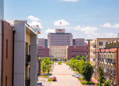 Bright urban street scene with modern buildings, a prominent flag-topped structure, and clear skies, evoking tranquility and positivity.
