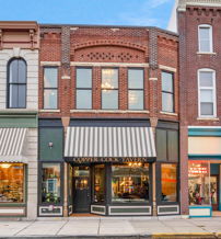 Charming street scene with distinctive storefronts, brick and painted facades, evoking nostalgia and warmth in a lively atmosphere.
